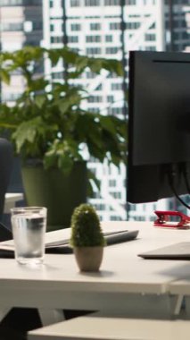 İş yerindeki monitörlerde dikey video iş grafikleri ve performans ölçümleri, el kamerası görüntüleri. Parlak kurumsal ortamda ofis masası kurulumu. Veri analizlerini görüntüleyen monitörler