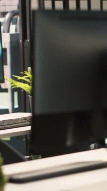 Ofisteki görüntülerde dikey video finans grafikleri ve KPI metrikleri, çekimler. Veri analizlerini gösteren bilgisayar ekranlarıyla canlı ve işbirlikçi modern çalışma alanı, yakın çekim