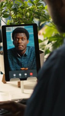 Ofisteki dikey video işçisi çevrimiçi video görüşmesi sırasında görev ilerlemesini denetleyen müdürle konuşuyor. Çalışan, uzaktan telekonferans sırasında yapılan işleri denetleyen denetleyici ile konuşuyor.