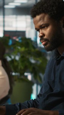 Ofisteki dikey video çalışanı tabletteki gelir rakamlarını sunmak için masadan ayrılıyor. Şirket istatistiksel numaralarını aygıt üzerinde karşılaştırmak için muhasebeci bitirme projesi görevi, verileri sunacak, kamera