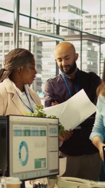 Ofisteki dikey video çalışanları beyin fırtınası yapıyor, finansal tabloları inceliyor, iş performans ölçümlerini analiz ediyorlar. İş yerinde çalışan iş arkadaşları sohbet ediyor, veri eğilimlerini inceliyor, kamera B