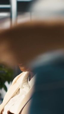 Dikey video amiri çalışanı tebrik ediyor. Ofisteki mutlu yönetici, iyi anahtar performans göstergelerini gördükten sonra memnun oldu. İşçi ve kamera A ile beşlik çaktı.