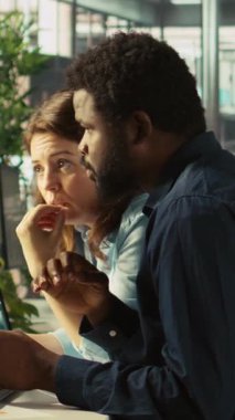 Ofis masasının yanındaki dikey video yöneticisi mali rakamları kontrol ediyor, raporlar hazırlıyor. Takım lideri ve adam birlikte çalışıyor. Evrak dosyaları ve kamera B 'deki verileri karşılaştırıyorlar.