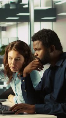 Bilgisayara finansal rakamlar girerek ve raporları kontrol ederek muhasebeci tarafından yapılan dikey video yöneticisi denetimi. Ofiste çalışan bir adamın verileri karşılaştırma sürecini denetleyen denetleyici.