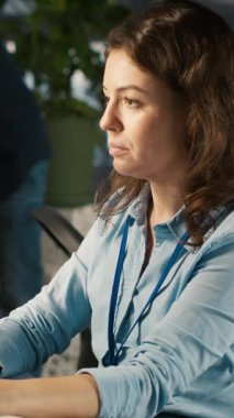 Ofis masasında çalışan dikey video çalışanı klavyeye yazı yazıyor, bilgisayardaki belgeleri düzenliyor. İşçi PC 'nin iş yerindeki hesap tablolarına veri giriyor, istatistiksel bilgiler üzerinde çalışıyor, kamera A