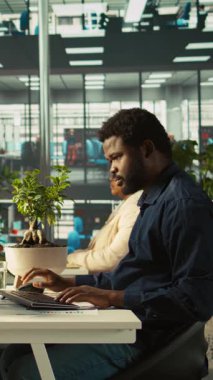 Ofisteki dikey video çalışanı tabletteki gelir rakamlarını sunmak için masadan ayrılıyor. Şirket istatistiksel numaralarını aygıt üzerinde karşılaştırmak için muhasebeci bitirme projesi görevi, verileri sunacak, kamera