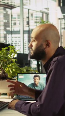 Dikey video sektörü yöneticisi, kar büyümesi için yeni fikirleri paylaşmak amacıyla brifinge katılan işçilerle görüntülü görüşme yapıyor. Başlangıç evrimini açıklamak için tablet kullanan çevrimiçi tele çalışma uzmanı