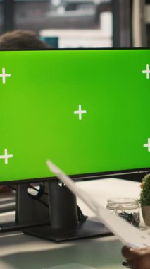 Projeyi tamamlamak için izole ekran PC görüntüsü kullanan dikey video çalışanı iş başında. Afrika kökenli Amerikalı ofis çalışanı, bilgisayar monitörü ve kamera A 'nın veri istatistiklerini okuyor.