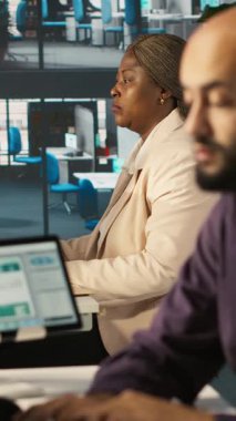 Bilgisayarla uğraşan modern başlangıç ajansındaki dikey video muhasebecisi, müdürümün raporları kontrol etmesini isterken araya girdi. Ofiste çalışan bir işadamı. Amirinin görevi evrakları karşılaştırmak.