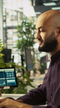 Vertical Video Startup çalışanı gelir, karlılık ve operasyonel verimlilik için kilit performans hedeflerini tutturmaya çalışıyor. Bilgisayar masası çalışanı araştırma analizi yapıyor. Kamera B, kapat.