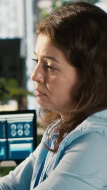 Ofisteki stresli çalışanın dikey videosu incelenemeyecek kadar çok belgenin yükü altında. İş yerindeki yorgun çalışanlar iş performans ölçümlerini ve kamera A 'yı incelerken kendilerini çok yorgun hissediyorlar.