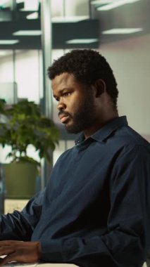 Modern ofiste verileri bilgisayara girdikten sonra arkadaşlarına mesaj atmak için cep telefonu kullanan dikey video muhasebecisi. İşyerinde çalışan akıllı telefondan yazı yazarken bilgisayar ve kamera B 'deki görevleri tamamlıyor.