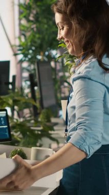 Dikey videolu Happy çalışanı yeni işindeki ilk günden başlıyor. Eşyaları yerleştiriyor, iş arkadaşlarıyla görüşüyor. Neşeli işçi ofise geliyor, yeni şirket pozisyonu üzerinde çalışmaya başlıyor, takım tarafından karşılanıyor.