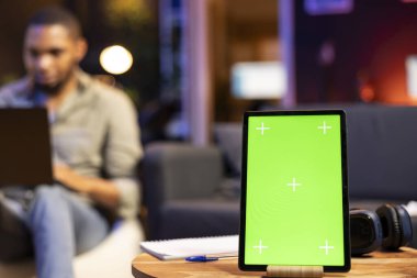 Afro-Amerikalı bir adam cep telefonunun yanındaki fotokopi makinesinin yanında rahatlarken kendini tatmin olmuş ve rahat hissediyor. Oturma odasındaki genç serbest çalışan uzaktan kumandayla mutlu..