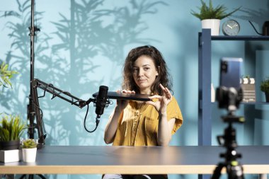 İnternet şovu sunucusu akıllı telefonu kullanıyordu. En iyi oyun dizüstü bilgisayarları hakkında içerik çekiyordu. İlgili izleyiciler için cep telefonu kullanan ortam yıldızı kayıt defteri denetlemesi