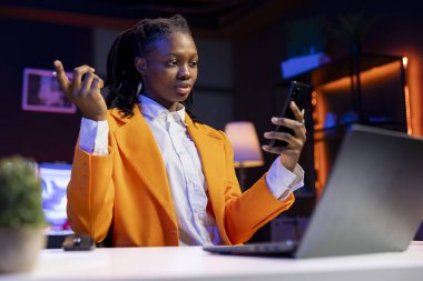 Neon ışıklı dairede akıllı telefon kullanan bir kadın telekonferans toplantısında arkadaşlarıyla tartışıyor. Çevrimiçi video görüşmesi sırasında arkadaşlarıyla buluşan genç bir kız.