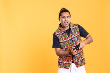 Denetleyici ve stüdyo geçmişi olan neşeli bir adam video oyunları oynuyor. Oyuncuların portresi gülümsüyor, konsol sistemi kullanılarak PVP online çoklu oyuncu oyununa katılarak eğleniyor