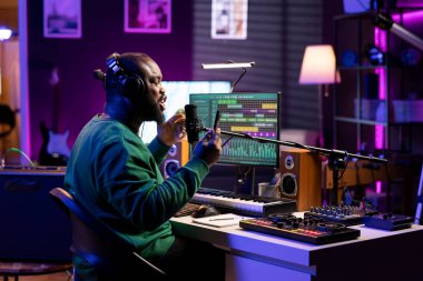 Kendine güvenen bir müzisyen kendi şarkısının sözlerini okumak için telefonuyla kendi şarkısını söylüyor, kendi şarkısının kaydını tutmak için ev stüdyosundaki bir mikrofonu kullanıyor ve bunu post prodüksiyonda düzenliyor. Mutlu sanatçı müzik yapıyor..