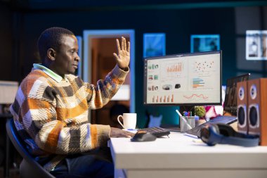 Afrika kökenli Amerikalı bir adam kişisel bilgisayar kullanarak muhasebe bilgisi hakkında konuşuyor. Çevrimiçi iletişim kuran ve aylık gelir dengesini inceleyen genç yetişkinler.