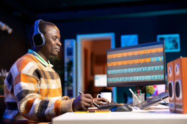 Fotoğraf editörü evdeki dijital çalışma alanında kurgu yazılımını kullanarak, sanat ve teknolojiyi dengeleyerek bu sektör için görsel projeler yaratıyor. Bilgisayar kurulumunda tasarımcı, rötuş üzerinde çalışıyor.