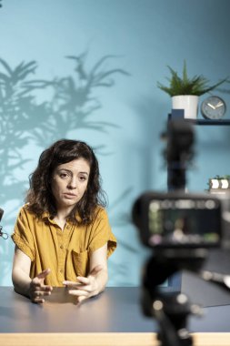 Depresyondaki kadın, seyircilerle ruh sağlığının önemi hakkında konuşuyor. İnternet şovuna ev sahipliği yaparken somurtan, profesyonel kameralı yüksek teknolojili mikrofon kaydı kullanan,