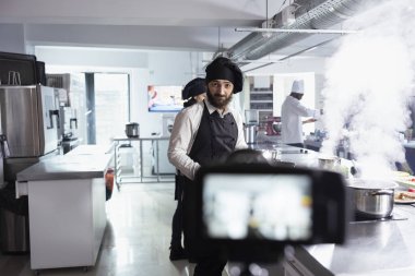 Şef, yemek hazırlama ve gastronomi tekniklerinin gösterildiği bir vlog dersi için detaylı bir yemek tanıtımı kaydediyor. Uzaktan kumandalı öğrencilere iyi yemek pişirme becerilerinde yardım etmek.