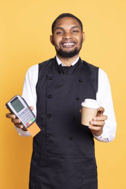 Beş yıldızlı restoran personeli yemek parası ve posizyon terminali için bahşiş istiyor. Hizmet odaklı sektördeki elektronik işlemleri sembolize ediyor. Yetenekli garson catering işinde çalışıyor..