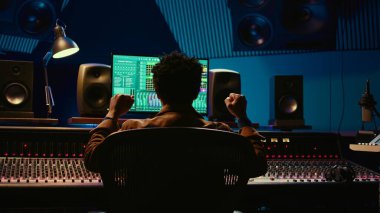 Afrika kökenli Amerikalı ses mühendisi konsolu karıştırma ve müzik endüstrisi sonrası prodüksiyon üzerine kaydettiği şarkıdan memnun. Ses teknisyeni kontrol odasında hit bir şarkı yapıyor. Kamera B.
