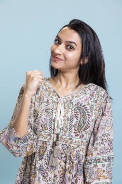 İyimser bir kızın portresi gülümseyen, olumlu duygular gösteren, kendine güvenen ve bir şey için tezahürat yapan. Stüdyoda kişisel başarının keyfini çıkaran kendinden emin bir insan..