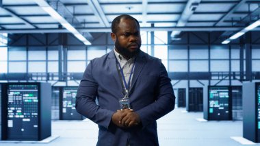 Veri merkezinde sunucu sıraları arasında yürüyen teknisyen, yıllık altyapı denetimi yapıyor. Sunucu merkezindeki sistem yöneticisi süperbilgisayar izleme ekipmanı, kamera A