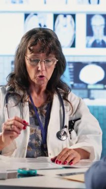 Dikey video deneyimli pratisyen hekim, yaşlı bir kadınla bakterilere karşı korunma ve önleme konularını tartışarak sağlık sigortası konusunda bir hastaya danışıyor. Uzman, tıbbi tavsiye veriyor.