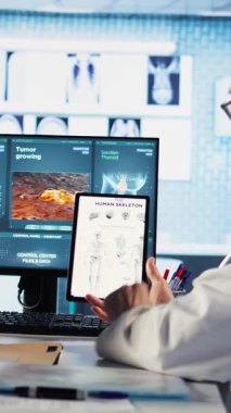 Dikey Video Sağlık Uzmanı uzmanlığını paylaşıyor ve MRI tarama sonuçlarını yorumluyor, check-up 'ta hasta kadına tavsiye ve destek veriyor. Doğru teşhis ve hasta bakımı. Kamera.