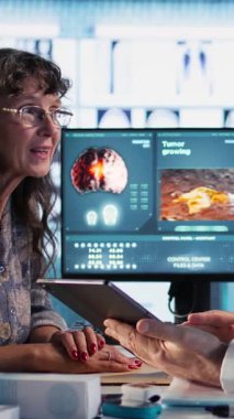 Dikey Video Uzmanı kadın hasta için tüm ilaç ve malzemeleri hazırlıyor. İyileşme için tedaviyi ve dozajı açıklıyor. İlaçları ve ilaçları reçete eden sağlık uzmanı