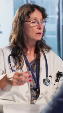 Dikey Video Uzmanı, sigortası olan eski bir hastanın röntgen taramalarını analiz ediyor, yaşlı bir hastayla sağlığın korunması ve önlenmesi konusunu tartışıyor. Profesyonel tavsiye. Kamera A.