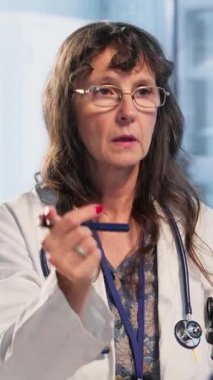 Vertical Video Professional sıhhiyecisi beyin sarsıntısı değerlendirmesi sırasında göz bebeğinin ışığa gösterdiği tepkiyi inceleyerek baş dönmesi, ışığa duyarlılık ve denge sorunlarını kontrol ediyor. Travma kontrolü.