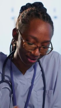 Dikey Afrikalı Amerikalı hemşire ve hastalar, sağlık ve iyileşme için doğru tedaviyi bulmak amacıyla sağlık kayıtları ve röntgen sonuçlarıyla rutin kontrollere girişirler. Sağlık Hizmetleri