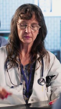 Dikey Görüntü kıdemli sıhhiyecisi hastaya hastalık teşhisinin kötü haberini veriyor. Ekranda x ışını görüntülemesi ile tıbbi konsültasyon. Sağlık sorunları ve profesyonel araştırmalar