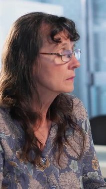 Yaşlı kadın hastalarla yapılan radyoloji taramasını inceleyen dikey video erkek onkoloji uzmanı, risk faktörlerini ve kanser teşhisi ve tedavisi için önleyici seçenekleri açıklıyor. İmmünoterapi.