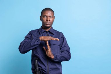 Afrikalı Amerikalı gardiyanlar stüdyodaki mola sembolü için izin istiyor. Görev başındayken kendini çok yorgun hissediyorlar. Ajan üniformalı adam dinlenmek için duraklama hareketi yapıyor..