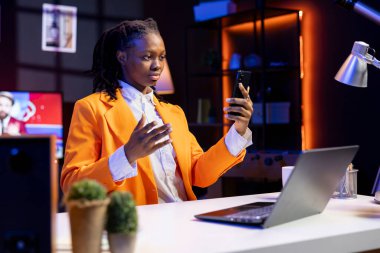 İnternetteki telefon konferansı sırasında yakın arkadaşlarını kontrol eden bir kadın. Kız, arkadaşlarıyla online video oturumunda akıllı telefondan eğleniyor.