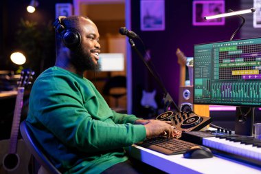 Ev stüdyosunda konsolu karıştırarak çalışan kendine güvenen müzik yapımcısı, bir şarkı için yeni melodiler üretiyor ve Dawson platformunda ses düzeylerini düzenliyor. Ses mühendisi ses dosyalarını kaydediyor.