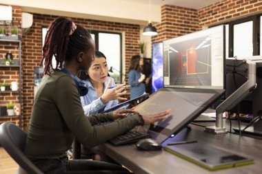 Çeşitli dijital sanatçılar bilgisayar ve dokunmatik ekran monitörü kullanarak grafik tasarımı ve multimedya projeleri üzerinde çalışıyorlar. Siyahi ve Asyalı kadınlar ortak çalışma alanında yaratıcı uygulamalar geliştiriyorlar.