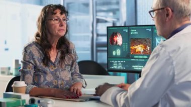 Erkek doktor, sağlık kontrolündeki kadının oksijen seviyesini ölçmek için oksimetre kullanıyor. İyileşmek için doğru tıbbi tavsiye. Aletle nabız ve doygunluk ölçülüyor. Kamera B.