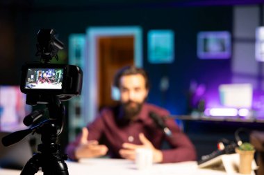 Bulanık arka planda mutlu edici tarafından kullanılan profesyonel kayıt cihazlarına odaklanın ve çevrimiçi yayın platformları için film yapın. Videoyu kaydetmek için insan tarafından kullanılan kamerayı kapat