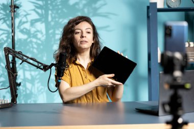 Marka sponsorluk videosundan bir tablet sunan teknoloji gurusu izleyicileri satın almaya teşvik ediyor. Teknoloji uzmanı, izleyicilere dijital cihaz reklamları yaparak pazarlamayı etkiliyor