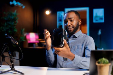 Teknoloji içeriği yaratıcısı yeni piyasaya çıkan VR gözlüklerini görüntülüyor. Deniyor ve izlenimlerini izleyicilere aktarıyor. İnternet yıldızı sanal gerçeklik aygıtını kontrol ediyor