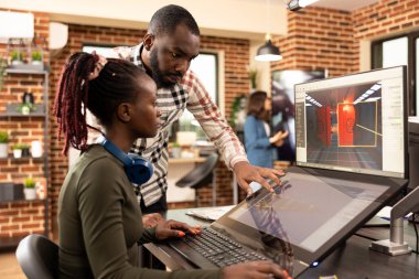 Modern çalışma alanında birlikte beyin fırtınası yapan siyahi erkek ve kadından oluşan yaratıcı bir ekip, grafik tasarım projelerinde işbirliği yapıyorlar. Afrikalı Amerikalı iş arkadaşları multimedya işleri için modern teknolojiden faydalanıyorlar.