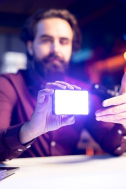 Teknik Guru 'nun teknoloji videoları tarafından incelenen mini ışıkların yakın çekim görüntüleri. Çevrimiçi yıldızın abonelere bulanık arka planda gösterdiği çekim ekipmanlarına odaklan, mikrofonla konuş