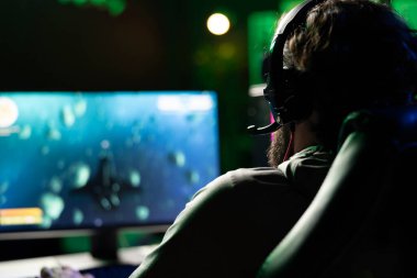 Oyuncu uzay gemisi uçan tekil oyuncu oyunu oynamak için kulaklık ve bilgisayar kullanıyor. HUD, sağlık, yakıt, cephane çubukları ve minimap 'ı gösteriyor. Uzay keşfi simülasyon oyunu oynayan, kulaklık takan bir adam