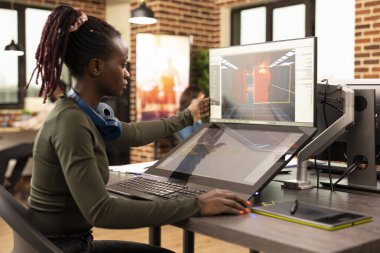 Girişimci bir şirkette, Afrikalı Amerikalı dijital sanatçı masaüstü ekranında yaratıcı bir projeyi analiz ediyor. Siyahi kadın çalışan, üretim departmanında tasarımları üzerinde çalışıyor.